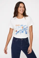 Remera blanca de manga corta con cuello redondo y estampado frontal ilustrativo de Santorini en tonos azules y naranjas.