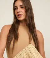 Vestido midi color beige, confeccionado en tejido de punto acanalado, sin mangas y de corte ajustado.