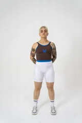 Musculosa deportiva marrón con cuello redondo y sisas con ribete azul. Diseño con doble tela y logo estampado en azul en el frente.