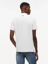 Chomba de piqué color blanco, de corte regular, con cuello y puños de punto canalé. Presenta cierre frontal de tres botones y logo bordado en el pecho de la colaboración entre Tommy Hilfiger y Cadillac Formula 1 Team.