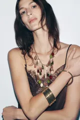 Pack de pulseras rígidas doradas, compuestas por múltiples aros delgados superpuestos, creando un efecto de brazalete ancho y texturizado.