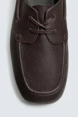 Zapato náutico de hombre, color marrón oscuro, fabricado en piel con acabado abatanado. Presenta cordones de piel, forro y plantilla interior de piel, y suela ultrafina.