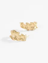 Aros de acero quirúrgico hipoalergénico color dorado, con forma de medialuna y textura irregular.