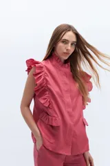 Chaleco celeste de lino con cuello mao, cierre frontal con botones y volados en hombros y bolsillos.