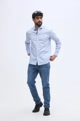 Camisa de manga larga fit semi slim color celeste, con cierre frontal de botones y cuello camisero clásico.