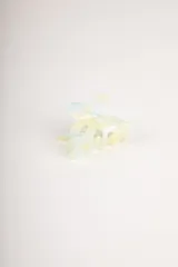 Pinza para el pelo de plástico con diseño de marmoleado en tonos celeste, amarillo y blanco.