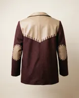 Blazer sastrero de lana bordó con trama espigada, silueta oversized, solapas clásicas, cierre de un botón y detalles en cuero natural.