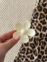 Broche para el pelo con forma de flor margarita, acabado mate y diseño minimalista.