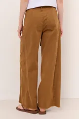 Jean tostado de corte wide leg, tiro medio con presillas y lazo ajustable en la cintura. Presenta bolsillos delanteros y traseros, costuras decorativas verticales y terminación desmechada en el ruedo.