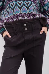 Pantalón blanco de tiro alto con elástico interno en la cintura, botones falsos y terminación con volado. Tiene bolsillos aplicados en delantero y falsos en espalda.