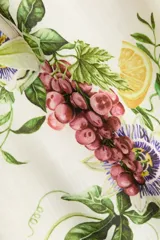 Vestido midi de color blanco con estampado botánico de frutas y flores, escote cuadrado, breteles finos y falda con vuelo.