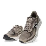 Championes de running New Balance con tecnología Fresh Foam en la entresuela. Presentan un diseño en tonos marrones y beige con malla transpirable y refuerzos sintéticos, destacando el logo N en contraste lateral.