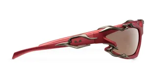 Lentes de sol con montura envolvente color rojo mate y detalles metálicos de líneas orgánicas. Cuentan con lentes de nylon color marrón con protección UV400 categoría 3.