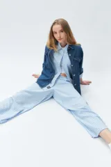 Pantalón largo de tela rayada celeste y blanco, con cintura elástica.