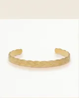 Esclava abierta de acero con baño de oro, con diseño trenzado en relieve.