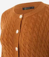 Cárdigan de punto trenzado color marrón, con cuello redondo, manga larga y cierre frontal con botones metálicos. Presenta puños y ruedo acanalados.