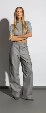 Pantalón cargo gris de cuero sintético, corte ancho y bolsillos laterales con solapa.