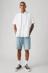 Bermuda de jean con corte holgado, tiro medio y lavado claro. Presenta diseño de cinco bolsillos, cierre frontal con botón y bragueta, y ruedo con terminación clásica.