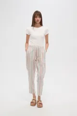 Pantalón tipo babucha de corte recto y holgado, con estampado de rayas verticales en tonos beige, blanco y verde agua. Cuenta con cintura elástica con cordón ajustable y borlas decorativas en los extremos.