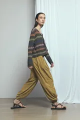 Pantalón barrel de lino color verde, de tiro medio con cintura elástica ajustable mediante cordón y bolsillos laterales.
