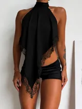 Top negro con cuello alto y diseño asimétrico, confeccionado con bordes de encaje detallados.