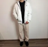 Campera tipo puffer color bordó con capucha, cierre frontal blanco y puños de tejido elástico. Presenta el logo de la marca bordado en el pecho.