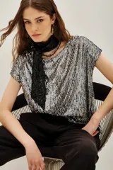 Remera de lentejuelas plateadas y negras, con escote redondo y mangas cortas.
