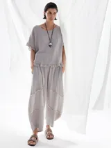 Blusa gris de lino con mangas cortas y volados en ruedo y mangas.