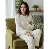 Conjunto de pijama de dos piezas confeccionado en tela de peluche suave con textura de rayas verticales. Incluye un buzo de manga larga con cuello redondo y un pantalón largo de corte holgado.