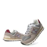 Championes urbanos New Balance modelo 574, color gris con detalles en bordó y blanco. Confeccionados en gamuza y malla, con el logo N característico en los laterales y entresuela con tecnología ENCAP.