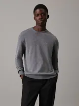 Sweater gris de Calvin Klein confeccionado en seda y algodón orgánico. Tiene cuello redondo y logo monograma de Calvin Klein estampado en el pecho.