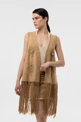 Chaleco de efecto gamuzado color beige, con detalles tejidos al crochet en forma de rombos, flecos largos en el ruedo y diseño sin mangas.