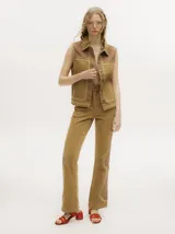 Pantalón de denim color tostado con tiro alto y corte oxford. Presenta detalles de apliques metalizados a lo largo de las costuras laterales y en los bolsillos.