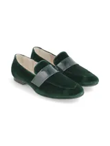 Mocasín de terciopelo verde oscuro, con detalle de antifaz en charol sintético sobre el empeine y suela plana con pequeño tacón.