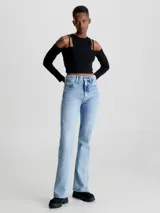 Remera Calvin Klein negra de punto canalé con doble capa y efecto 2 en 1. Tiene mangas largas con hombros descubiertos y logo bordado en el lateral. Corte slim cropped.