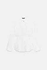 Camisa de popelín color blanco con cuello clásico, manga larga y cintura entallada con pliegues que generan un efecto peplum. Presenta cierre frontal con botones ocultos bajo solapa.