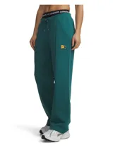 Pantalón deportivo de corte holgado y tiro medio, confeccionado en tejido French Terry color verde. Presenta cintura elástica con cordón ajustable, bolsillos laterales y detalle de pliegue frontal. Incluye un pequeño parche bordado con diseño de estrella y letras en la parte superior del muslo.