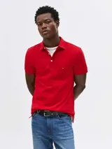 Chomba roja de corte slim, con cuello polo y cartera de dos botones. Logo de Tommy Hilfiger bordado en el pecho.
