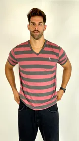 Remera de manga corta con cuello en V, diseño a rayas horizontales en color rosado y gris oscuro. Presenta un pequeño logo bordado en el pecho.