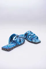 Sandalias planas con capellada de algodón estampada con diseño batik en tonos rosa y negro. Suela de neumáticos reciclados.