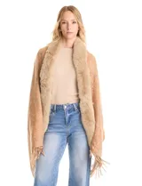 Ruana tejida con estampado de arabescos en tonos beige, con cuello y bordes frontales decorados con aplique de piel sintética y terminación con flecos en el ruedo.