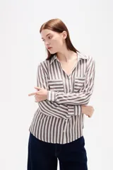 Camisa de viscosa con estampado de rayas verticales, cuello camisero, cierre frontal de botones y bolsillo en el pecho.