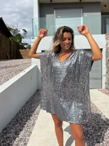Túnica tipo poncho de corte holgado y escote en V, completamente cubierta de lentejuelas plateadas brillantes.