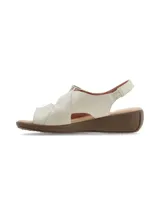 Sandalias de cuero color crudo con plataforma baja y suela marrón. Cuenta con tira ajustable con velcro en el empeine y diseño destalonado.