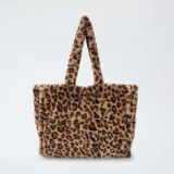 Bolso tipo shopper confeccionado en piel sintética con estampado de leopardo. Cuenta con dos asas superiores fijas y un diseño amplio y estructurado.