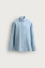 Camisa celeste de lino de corte regular fit, con cuello abotonado, manga larga y cierre frontal de botonadura.