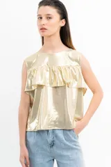 Blusa dorada sin mangas con volados en el pecho.