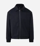 Campera masculina de corte boxy en color beige, con cuello inglés, cierre frontal de cremallera, mangas largas con puños elásticos y ruedo con elástico. Presenta bolsillos laterales y detalles de recortes en el diseño.