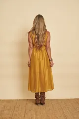 Vestido midi sin mangas de color mostaza, con escote en V cruzado y un lazo ajustable en la cintura.