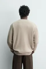 Jersey relaxed fit de punto en hilatura con mezcla de algodón y cashmere. Presenta cuello redondo con cierre frontal de botonadura y manga larga.